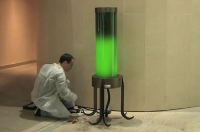 scientist with a glowing green lamp tube